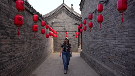 woman walking down a lantern-decorated traditional chinese alley in daylight with the word yamen written on them