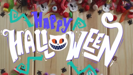 Animation-of-halloween-text-over-decorations-and-sweets-on-wooden-background