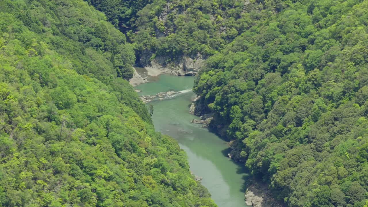 Aerial lush landscape of Arashiyama river water stream in Kyoto Japan, daylight