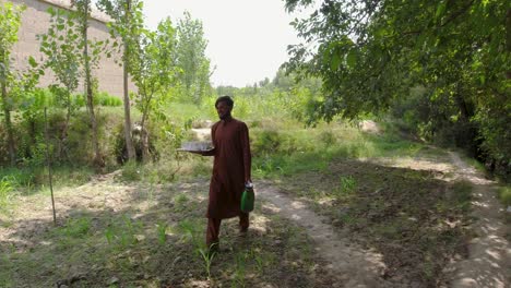 a young man carrying tea in a rural area