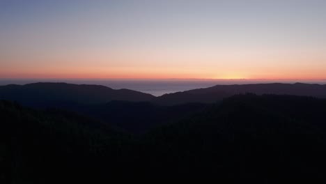 aerial drone shot of the mountain silhouette at sunset