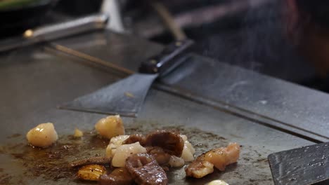 chef preparing food on a hot teppanyaki grill