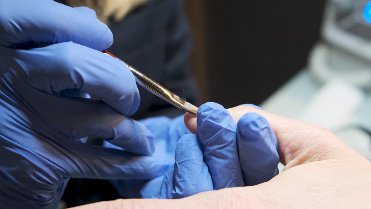 una mujer rica de mediana edad en un spa cosmético que recibe un esmalte de uñas brillante y un tratamiento de manicura por parte de una esteticista de uñas