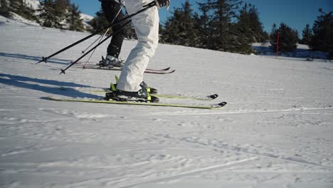 4k slow motion close up tracking of skis from the side going at high speed through the snow in a slope in norway on a sunny day with blue sky