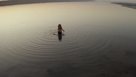 little girl bathes in a lake