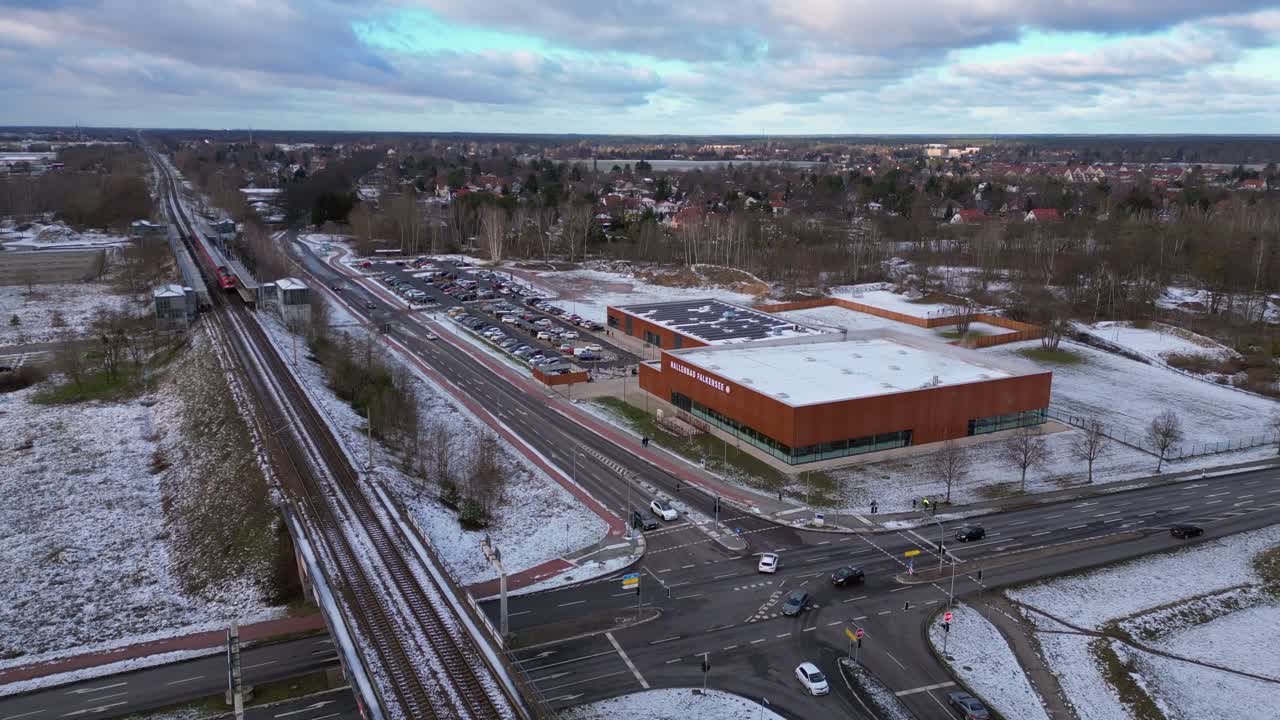 train traveling through a snowy cityscape in segefeld Falkensee. Amazing aerial view flight static tripod hovering drone
