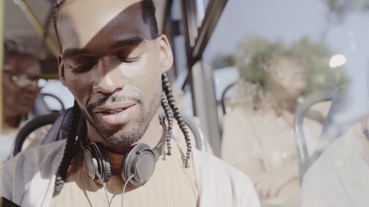 Man with Headphones Smiling on a Bus
