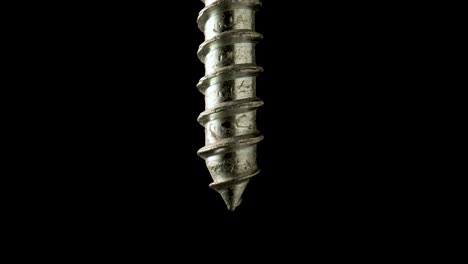 close-up of a metal screw on a black background