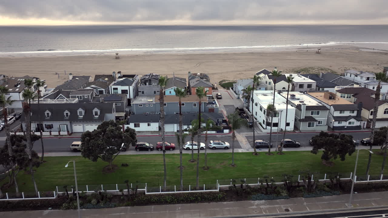 Foto aerea dall'alto di lussuose case fronte mare a Newport Beach, in California, sotto un cielo nuvoloso. Il clima piovoso ammorbidisce il paesaggio costiero, riflettendo un ritmo più lento lungo la costa di Orange County.