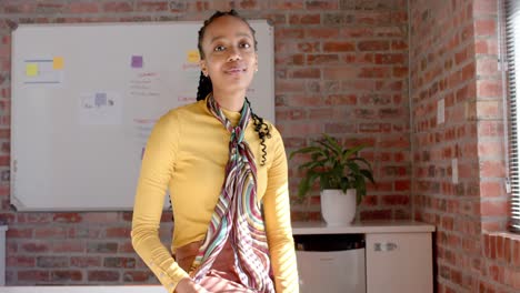 Portrait-of-happy-african-american-casual-businesswoman-in-sunny-office,-slow-motion