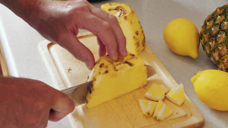 footage show a man slicing and cubing a pineapple ready for juicing