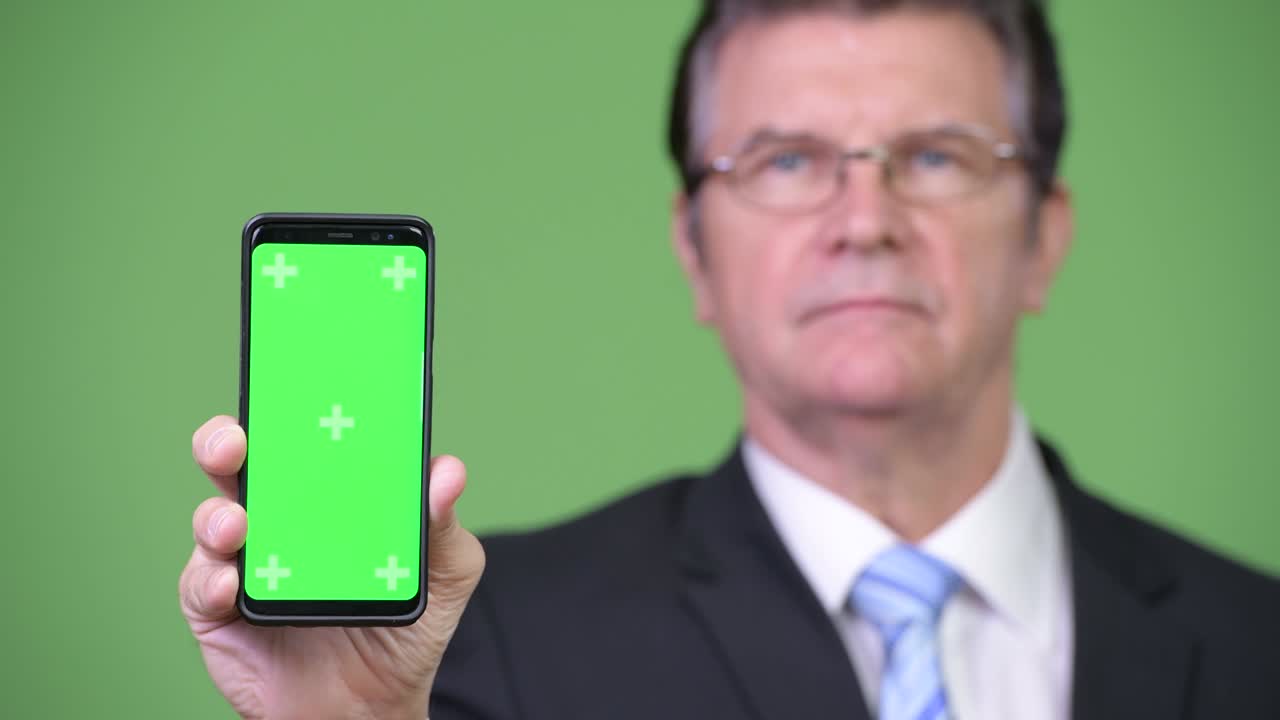Senior handsome businessman showing phone