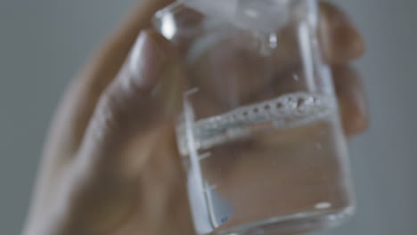 detailed close-up of a beaker in a laboratory with liquid substance in motion.