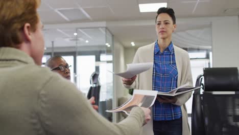 diversos colegas de negocios, hombres y mujeres, pasando papeles, intercambiando ideas y discutiendo en la oficina.