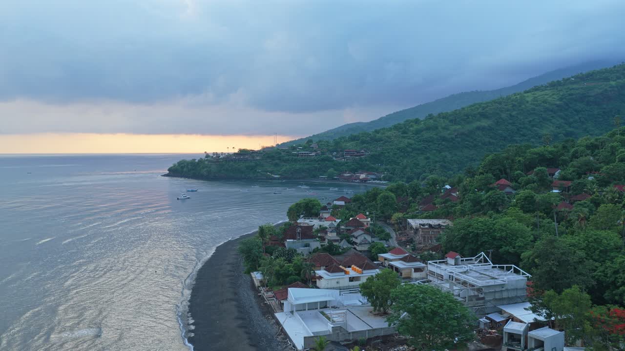 Aerial view flying over amed black sand beach at sunrise