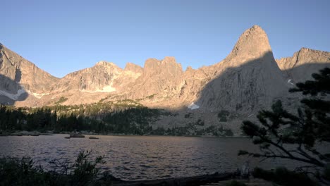 glow of light on cirque of the towers, highlighting the jagged peaks and calm natural beauty, pan reveal from pine tree