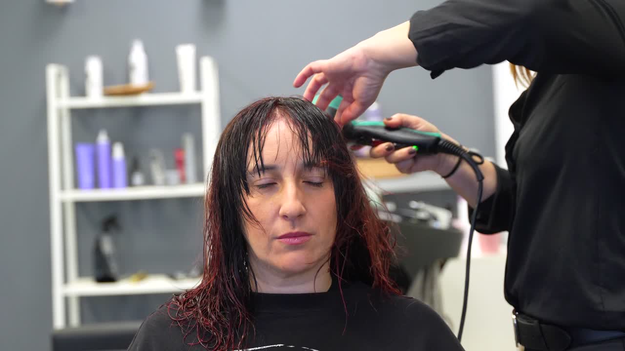 Donna che si fa tagliare i capelli in un salone di parrucchiere