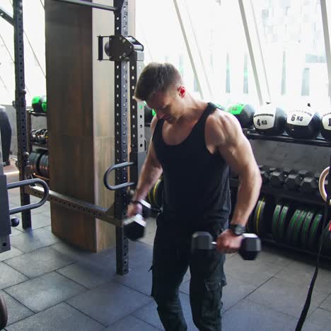 young sportsman in a modern gym. handsome athlete exercising with dumbbells. muscular bodybuilder actively training in luxury fitness club