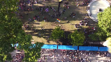 overhead scene of gay pride parade of buenos aires with waving rainbow flag