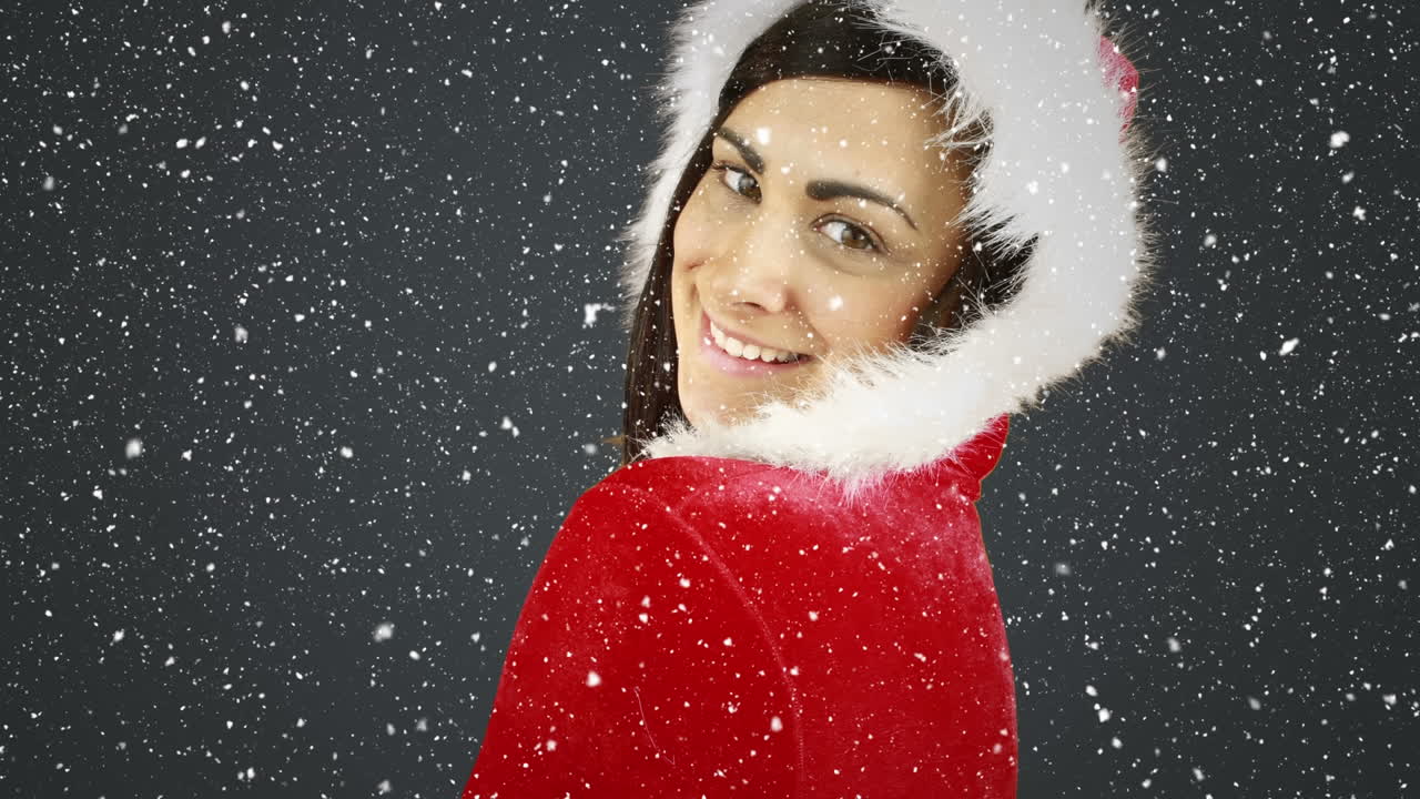 산타 의상을 입은 미소 짓는 소녀 위에 눈이 떨어지는 비디오 작곡