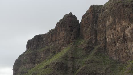 Unique-volcanic-rock-face-with-green-mossy-growth-and-deep-orange-colours