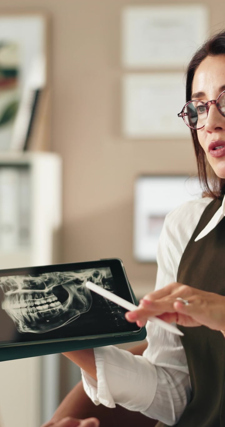 Dentist Explaining Dental X-ray to Patient on Tablet