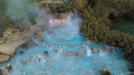 El-Baño-De-Aguas-Termales-Geotérmicas-Y-La-Cascada-En-Saturnia,-Toscana,-Italia-Cerca-De-Siena-Y-Grosseto-Al-Amanecer-Desde-Arriba