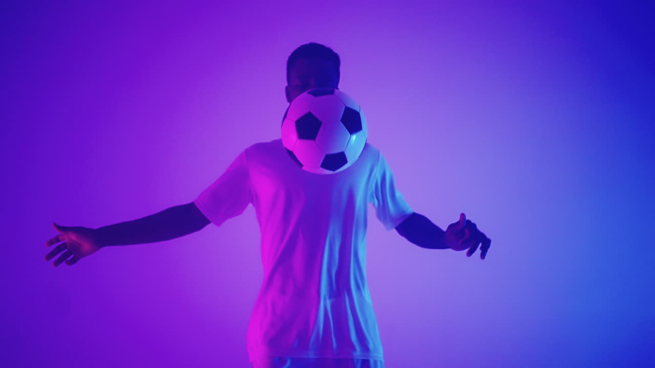 hombre negro africano estilo libre o jugador de fútbol profesional practicando con una pelota de fútbol haciendo malabares en las piernas en cámara lenta. disparo de estudio de un jugador de fútbol profesional con una pelota