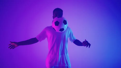 Black-african-man-Freestyle-or-professional-soccer-player-practicing-with-football-ball-juggling-on-legs-slow-motion.-Studio-shooting-of-a-professional-football-player-with-a-ball