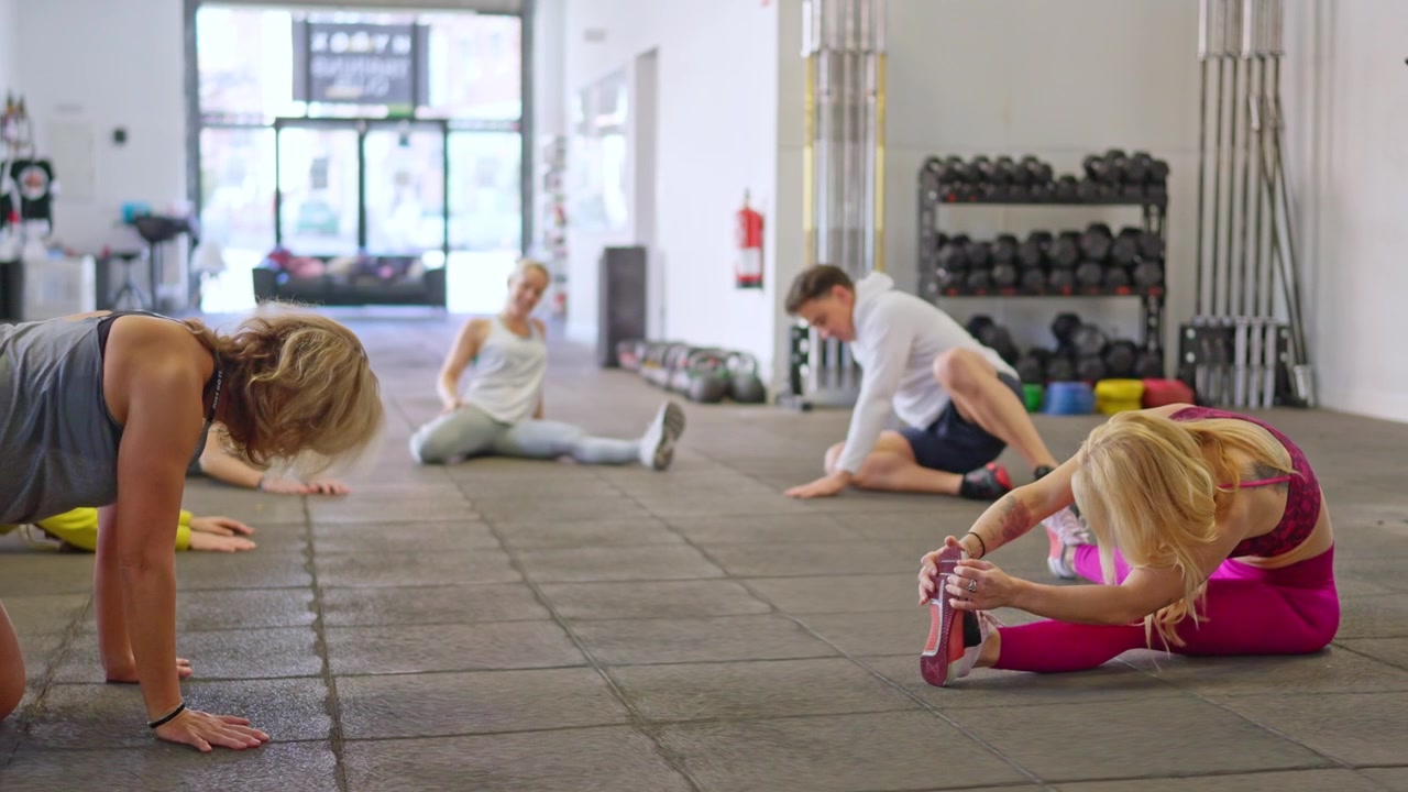 Group of People Stretching and Exercising in a Modern Gym