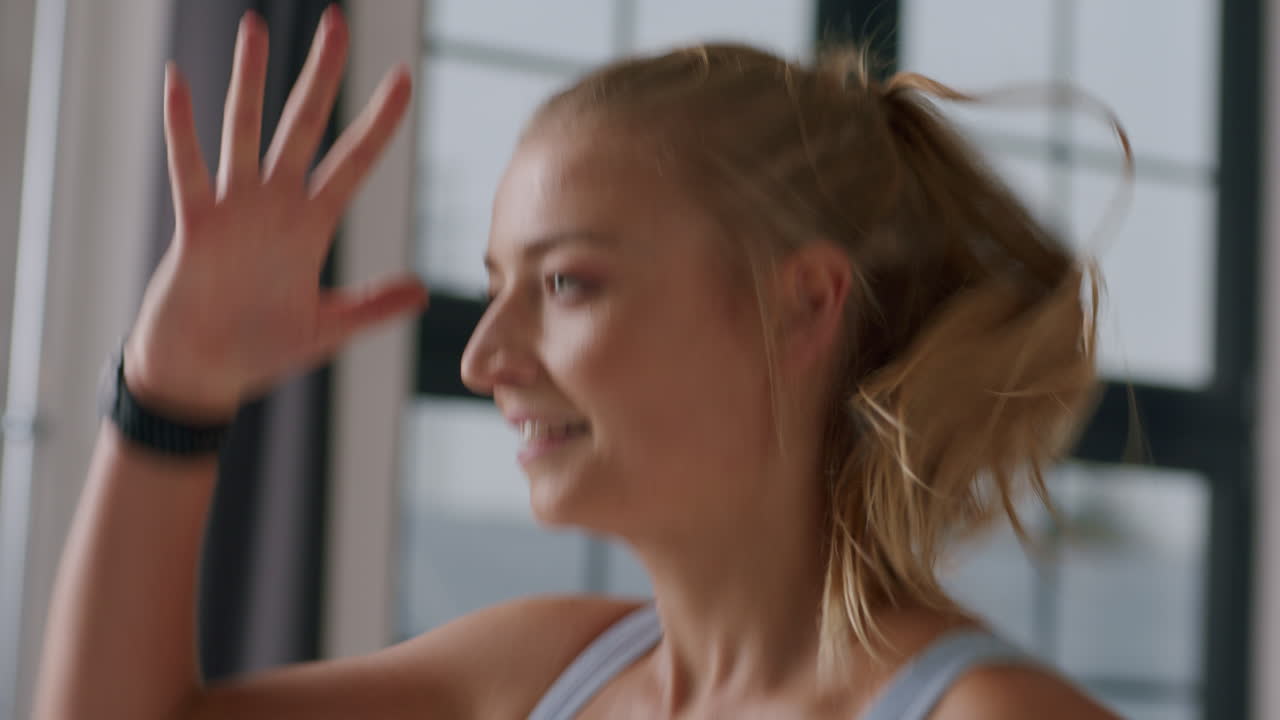 Gros plan latéral du visage et des mains d'une femme courant sur place lors d'un entraînement.