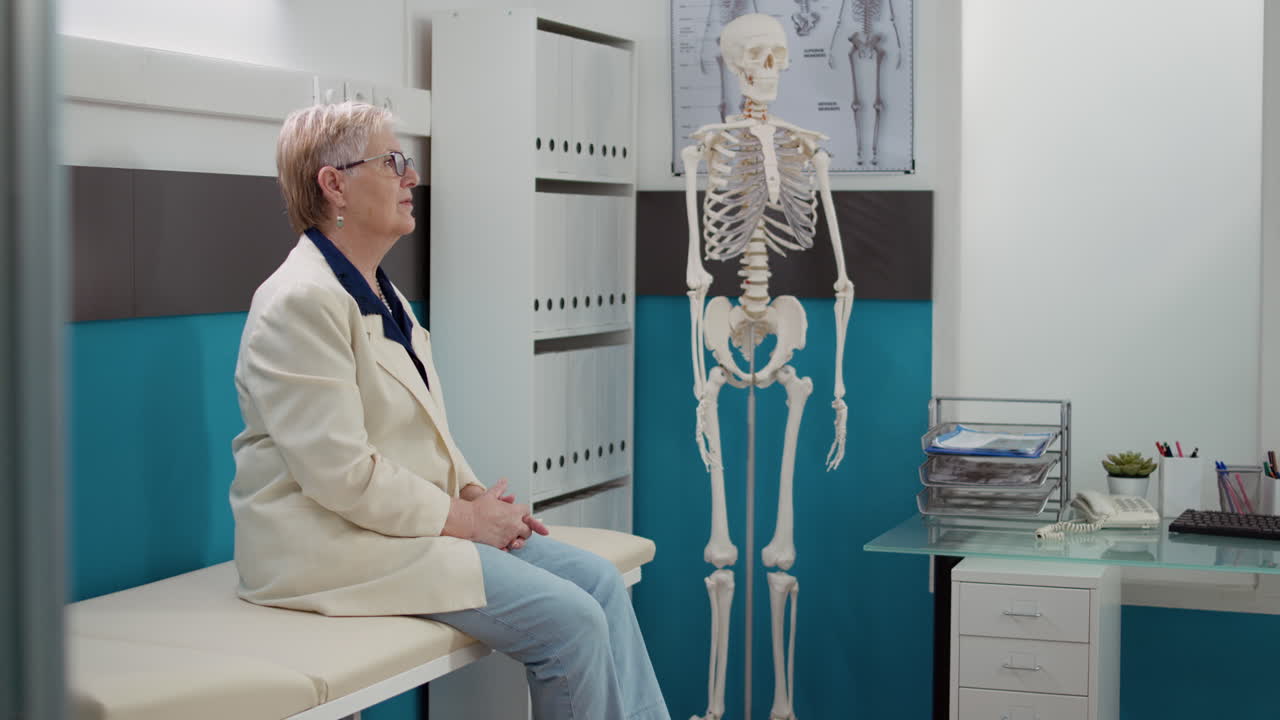 Elderly Woman Waiting in Doctor's Office with Skeleton Model
