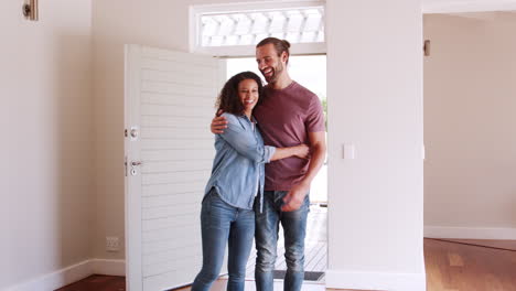 Couple-Opening-Door-And-Walking-In-Empty-Lounge-Of-New-Home