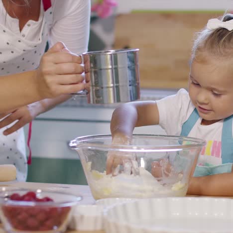 linda niña ayudando a su madre a hornear una tarta