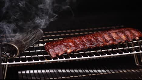 smoker and a full rack of baby back pork ribs with run and sauces