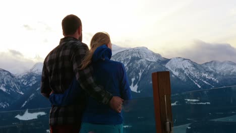 Couple-standing-and-embracing-each-other-on-snowy-landscape