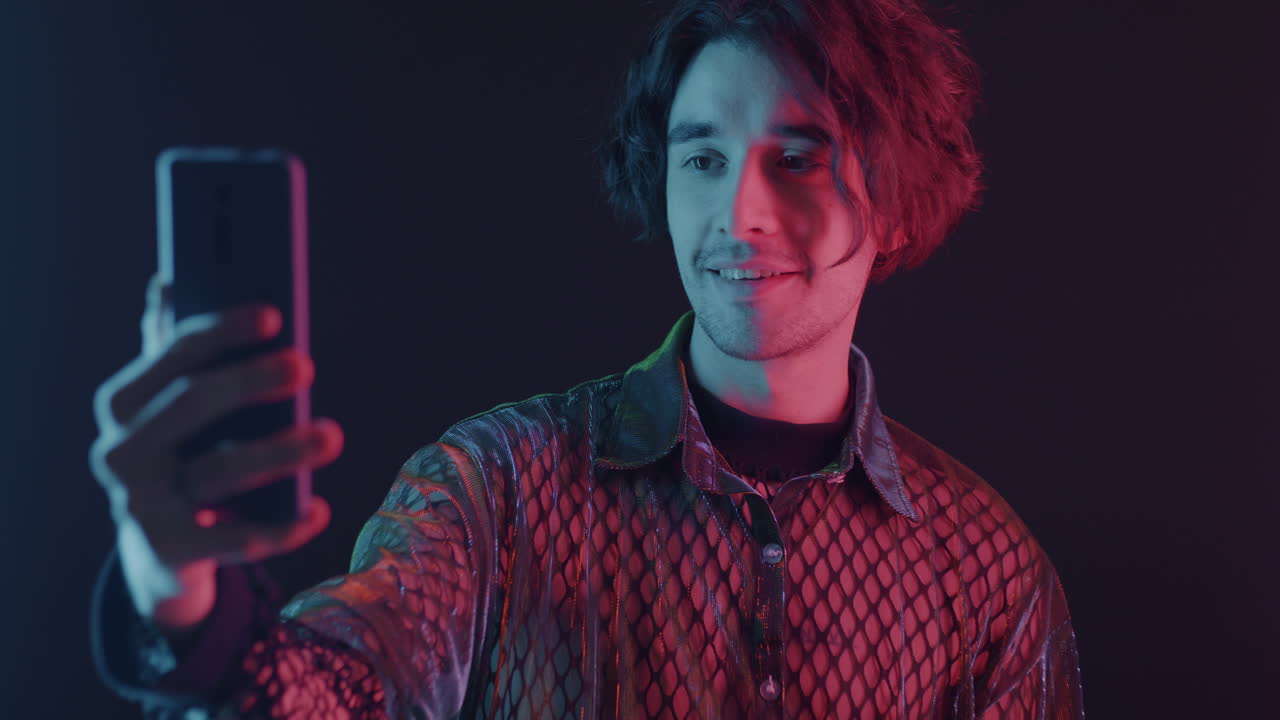 Man taking a selfie with colorful neon lighting