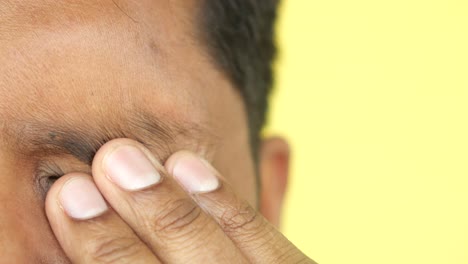 a close-up of a man's hand covering his eye