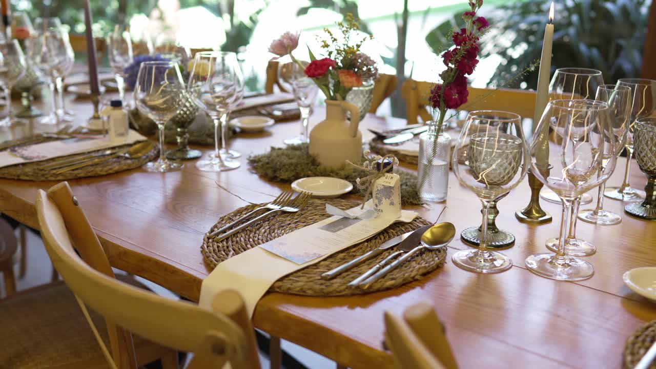 rustic wedding table setting with glassware flowers and candlelight in natural daylight