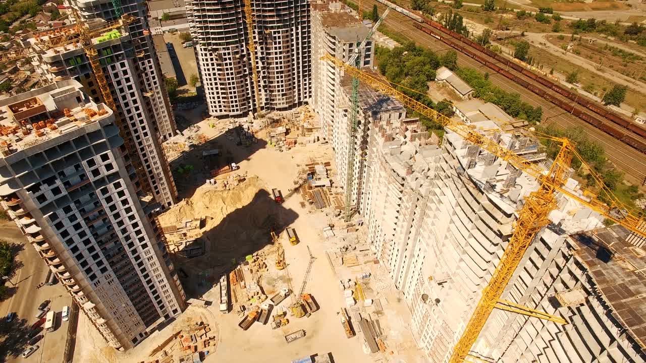 construcción de casas. aviones no tripulados vuelan sobre el sitio de construcción con grúas torre