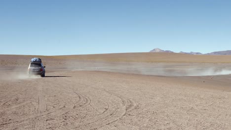 travelers in suv drives across the vast, arid terrain of bolivia sud lipez region, surrounded by dry heat