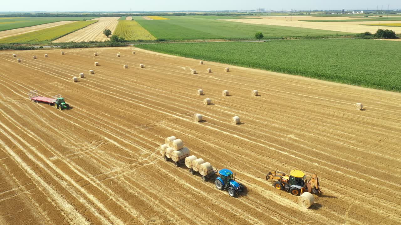 сверху вид на сельскохозяйственное поле, собирая круглые балы соломы