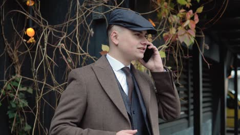 young stylish businessman talking on the phone on street. businessman talking mobile phone in the city. portrait of a handsome man having a phone talk outdoors