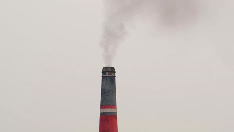 Bunter-Ziegelsteinkamin,-Der-Schwarzen-Rauch-Vor-Einem-Grauen-Himmel-Ausstößt