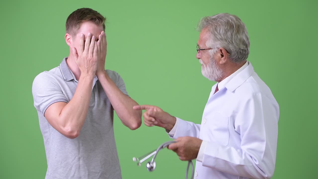 노인 수염 남자 의사 상담 남자 환자 초록색 배경