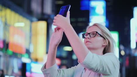 Porträt-Einer-Attraktiven-Frau,-Die-Sehenswürdigkeiten-Auf-Dem-Times-Square-Fotografiert,-Es-Steht-Auf-Dem-Hintergrund