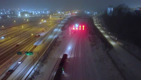 Commuter-train-or-tram-transits-across-snow-covered-tracks-next-to-busy-highway-in-Montréal,-Québec,-Canada