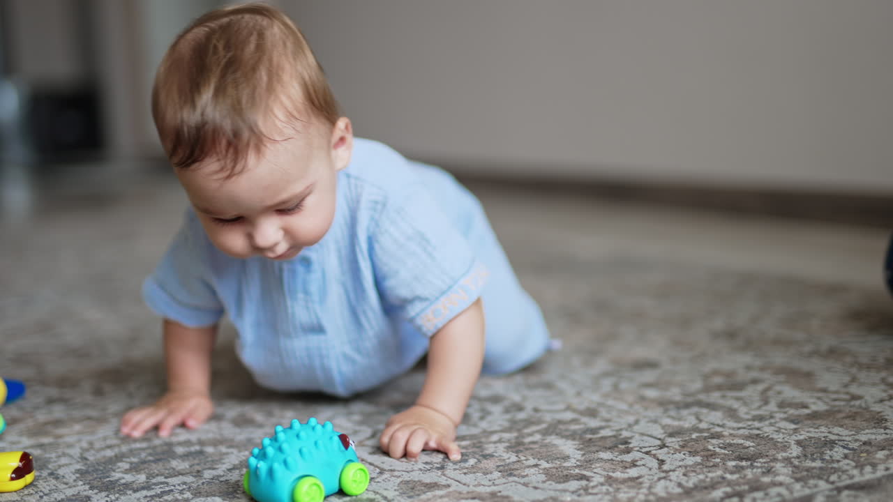Healthy cute kid playing on the floor. Funny boy moves actively and smiling adorably. Close up. Blurred backdrop.