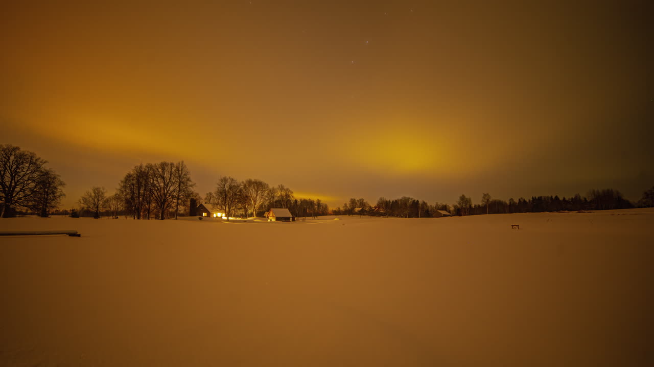탁 트인 하늘 아래 집의 야간 시간 경과와 일부 나무가 배경에 있습니다.