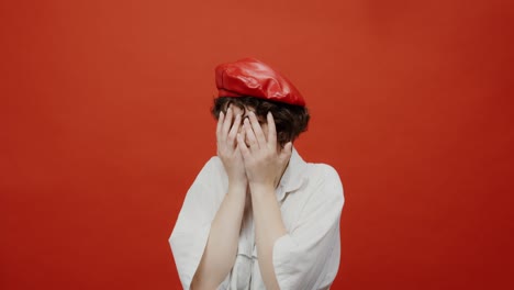 woman in red beret hiding face